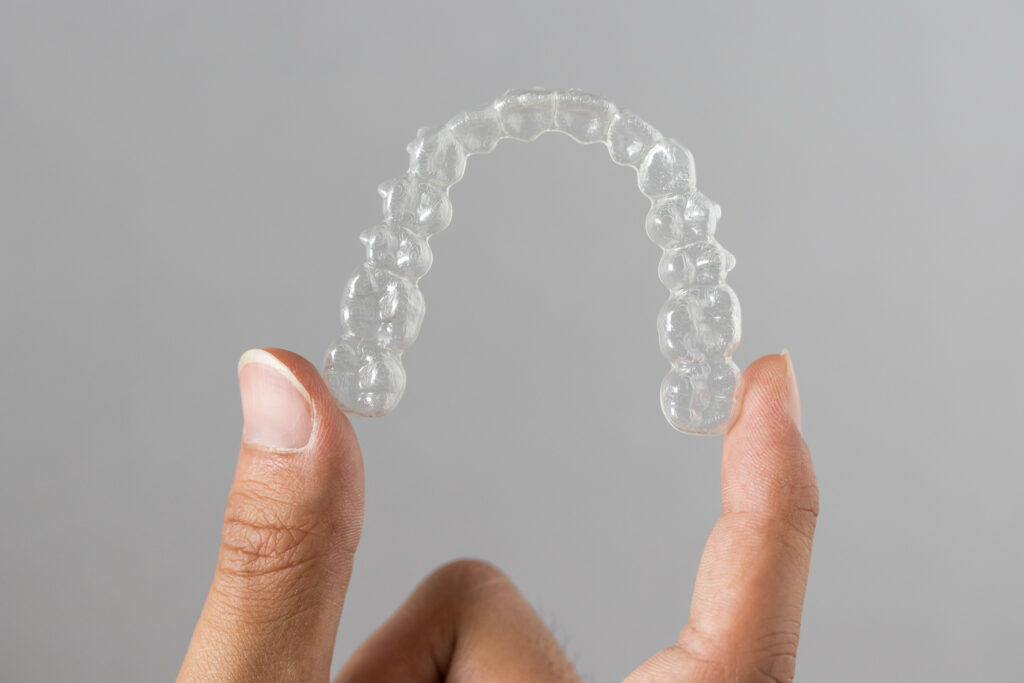 Closeup of a hand holding an Invisalign tray